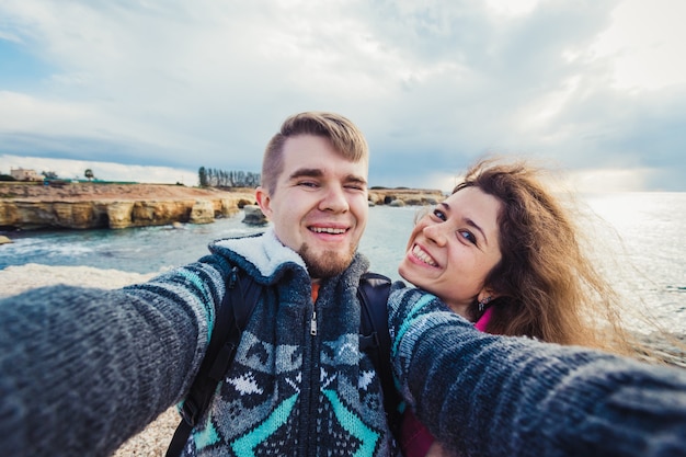 Jonge gelukkige paar neemt selfie foto op vakantie in de buurt van zee.