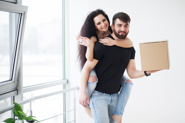 Jonge gelukkige paar praten terwijl ze in hun nieuwe huis staan.