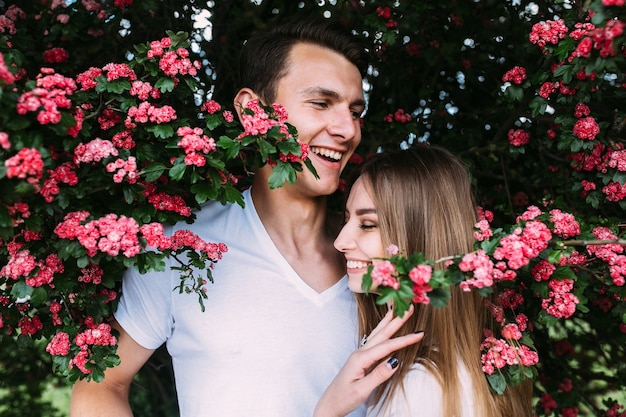 Jonge gelukkige paar verliefd buitenshuis. liefdevolle man en vrouw op een wandeling in een lente bloeiend park