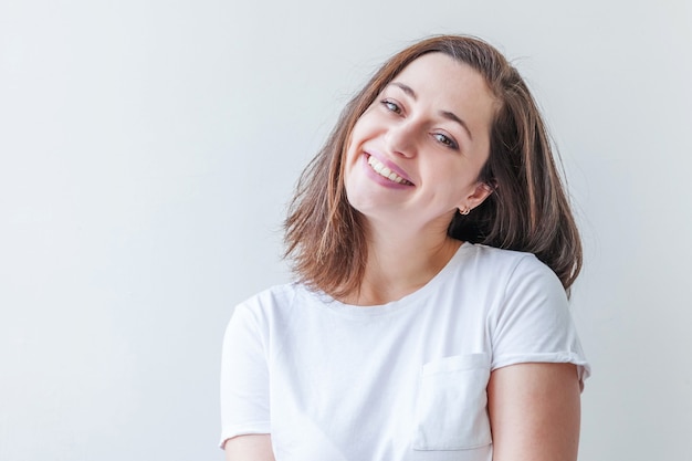Jonge gelukkige positieve vrouw geïsoleerd op een witte achtergrond