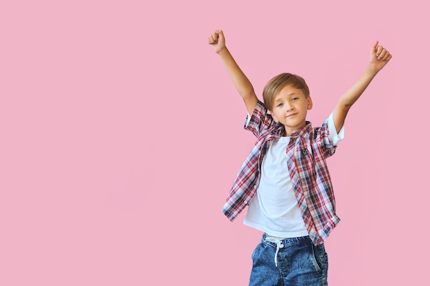 Jonge gelukkige tienerjongen met in casuals op roze achtergrond