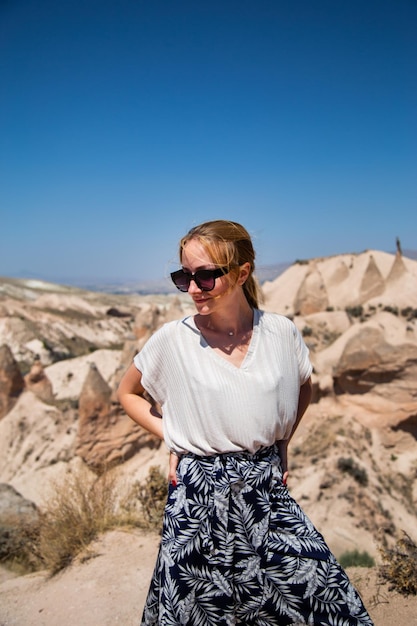 Jonge gelukkige toeristische vrouw reiziger in zonnebril genieten van een vakantie in de woestijn Cappadocië Turkije