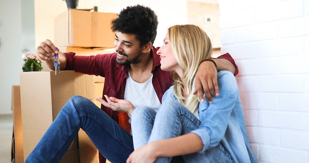 Jonge gelukkige verliefde paar verhuizen naar een nieuw huis en dozen uitpakken