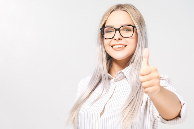 Jonge gelukkige vrolijke vrouw die duim toont