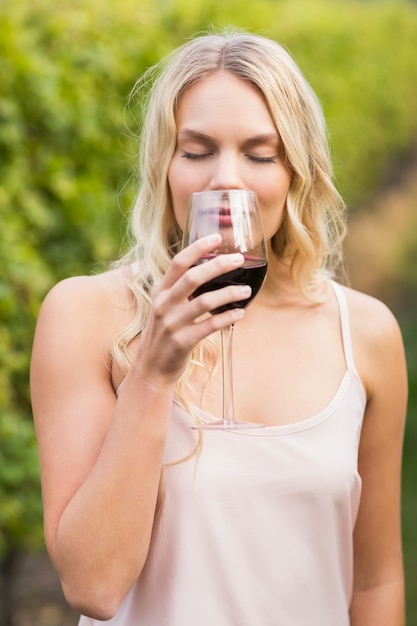 Jonge gelukkige vrouw die een glas wijn houdt