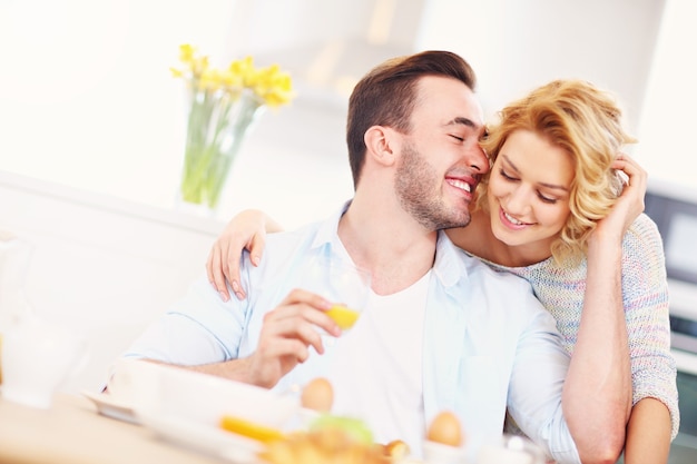 jonge gelukkige vrouw die goedemorgen knuffel geeft aan haar man