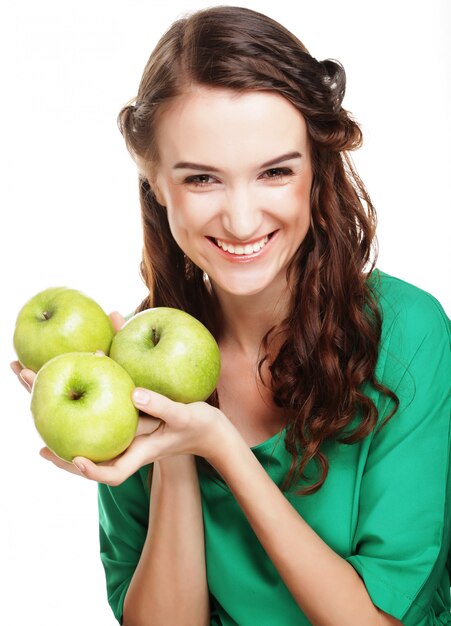 Jonge gelukkige vrouw die groene appelen houdt.