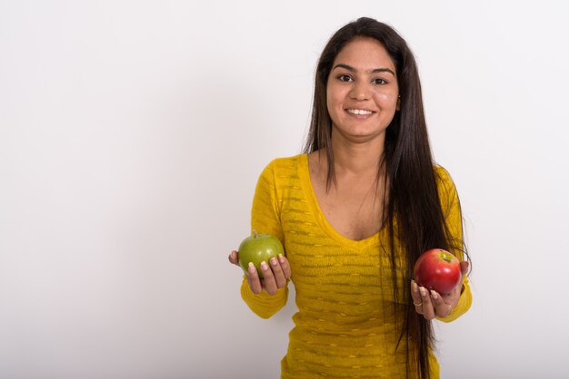 Jonge gelukkige vrouw die lacht terwijl rode appel en groene appel