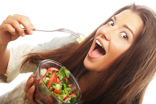 Jonge gelukkige vrouw die salade eet