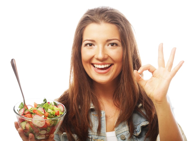 Foto jonge gelukkige vrouw die salade eet