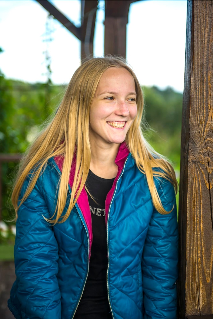 Foto jonge gelukkige vrouw die tegen de boom staat