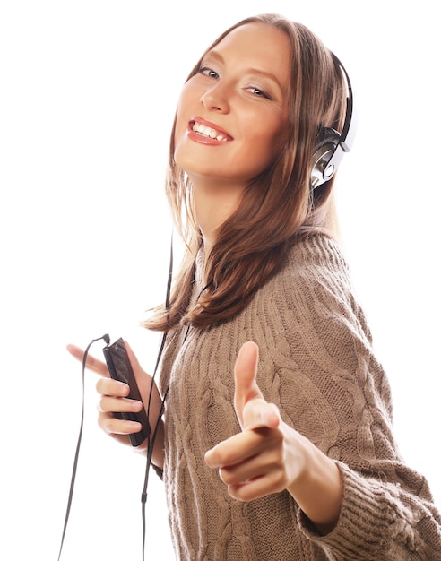 Jonge gelukkige vrouw met koptelefoon luisteren muziek op witte achtergrond