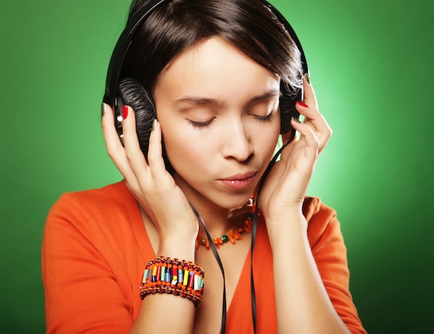 Jonge gelukkige vrouw met koptelefoon luisteren muziek