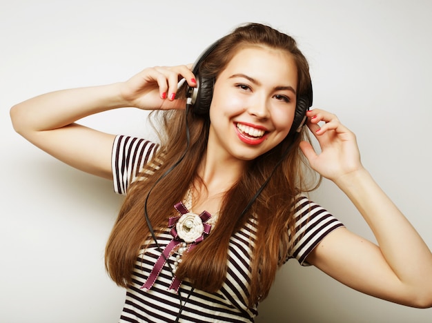 Jonge gelukkige vrouw met koptelefoon luisteren muziek