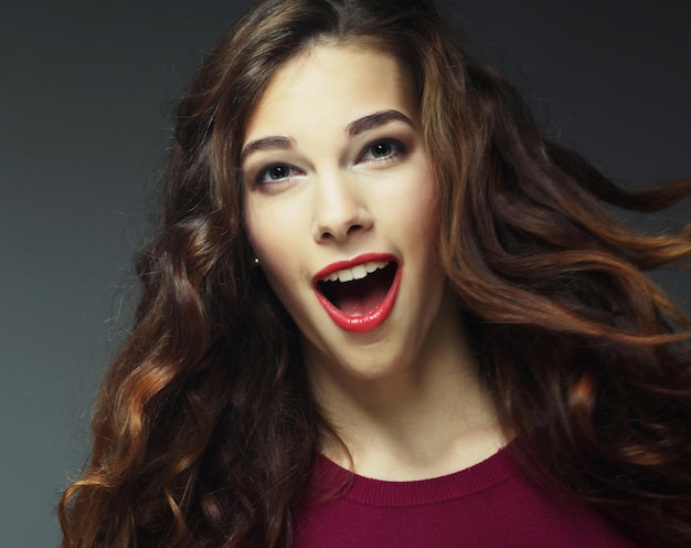 Jonge gelukkige vrouw met wind in haar studio shot