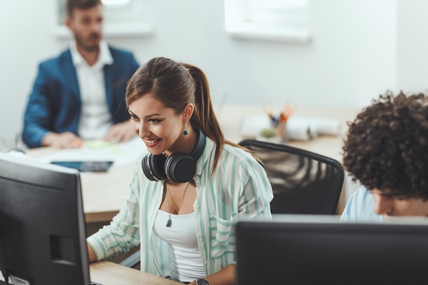 Jonge gelukkige vrouwelijke freelancer werkt aan een nieuw zakelijk project in het informele kantoor.