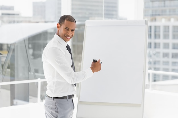 Jonge gelukkige zakenman die bij whiteboard met teller voorstellen