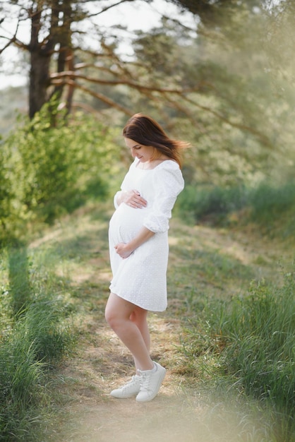 Jonge gelukkige zwangere vrouw ontspannen en genieten van het leven in de natuur Outdoor shot Copyspace