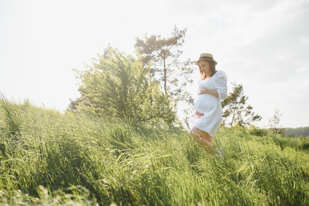 Jonge gelukkige zwangere vrouw ontspannen en genieten van het leven in de natuur Outdoor shot Copyspace