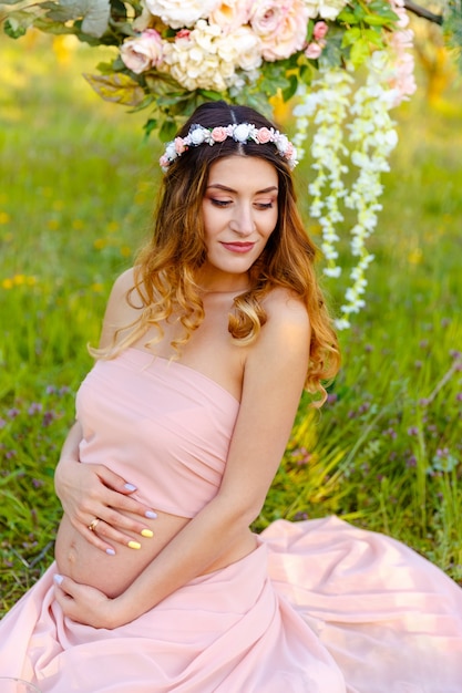 Jonge gelukkige zwangere vrouw ontspannen en genieten van het leven in de natuur