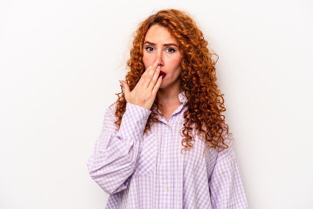 Jonge gember kaukasische vrouw geïsoleerd op een witte achtergrond geschokt die mond bedekken met handen angstig om iets nieuws te ontdekken