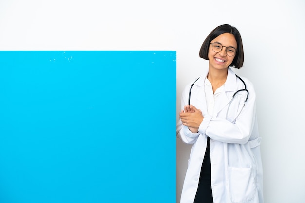 Jonge gemengd ras arts vrouw met een groot bordje geïsoleerd op een witte achtergrond applaudisseren