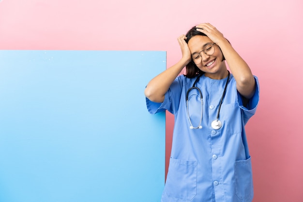 Jonge gemengd ras chirurg vrouw met een grote banner over geïsoleerde achtergrond lachen