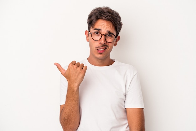 Jonge gemengd ras man geïsoleerd op een witte achtergrond geschokt wijzend met wijsvingers naar een kopie ruimte.