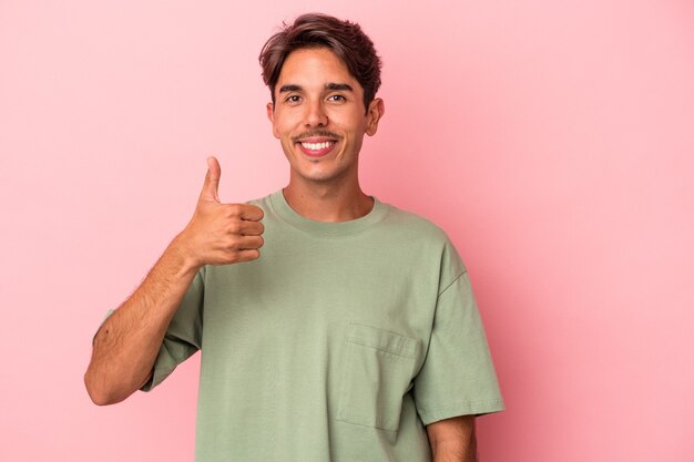 Jonge gemengd ras man geïsoleerd op een witte achtergrond glimlachend en duim omhoog