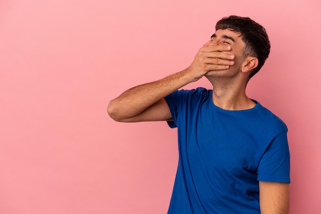 Jonge gemengd ras man geïsoleerd op roze achtergrond lachen gelukkig zorgeloos natuurlijke emotie