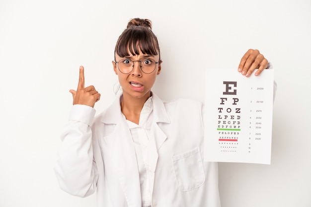 Jonge gemengd ras opticien vrouw doet een test geïsoleerd op een witte achtergrond met een teleurstelling gebaar met wijsvinger.