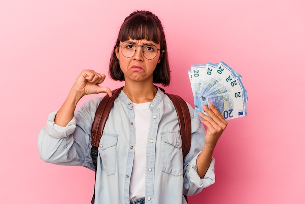 Jonge gemengd ras student vrouw met rekeningen geïsoleerd op roze achtergrond voelt trots en zelfverzekerd, voorbeeld te volgen.