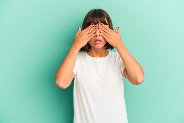 Jonge gemengd ras vrouw geïsoleerd op blauwe achtergrond met hoofdpijn, voorkant van het gezicht aan te raken.