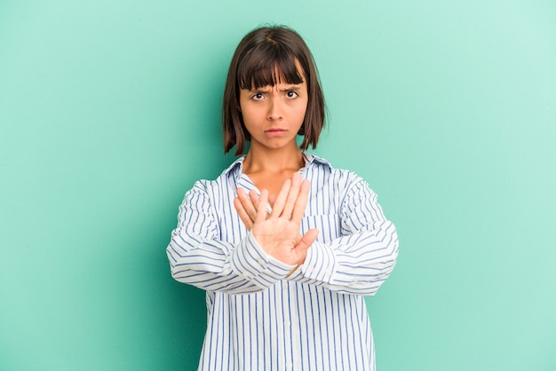 Jonge gemengd ras vrouw geïsoleerd op blauwe achtergrond wijst naar beneden met vingers, positief gevoel.