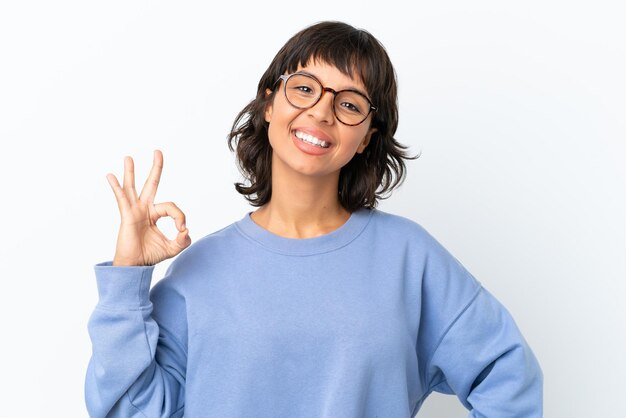 Foto jonge gemengd ras vrouw geïsoleerd op een witte achtergrond met een bril en doen ok sign