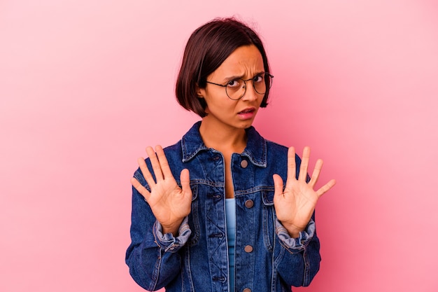 Jonge gemengd ras vrouw geïsoleerd op roze achtergrond permanent met uitgestrekte hand weergegeven: stopbord, voorkomen dat u.