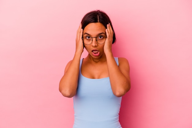 Jonge gemengd ras vrouw geïsoleerd op roze achtergrond schreeuwen, erg opgewonden, gepassioneerd, tevreden met iets.