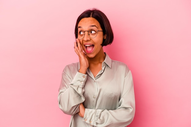 Jonge gemengd ras vrouw geïsoleerd op roze schreeuwen opgewonden naar voren.