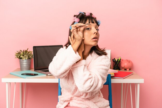 Jonge gemengd ras vrouw harsen van de wenkbrauwen geïsoleerd op roze background