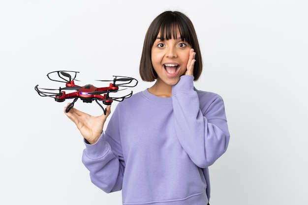 Jonge gemengd ras vrouw met een drone geïsoleerd op een witte achtergrond met verrassing en geschokte gezichtsuitdrukking