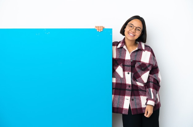 Jonge gemengd ras vrouw met een groot blauw bordje geïsoleerd op een witte achtergrond lachen