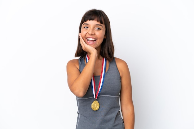 Jonge gemengd ras vrouw met medailles geïsoleerd op een witte achtergrond met verrassing en geschokte gezichtsuitdrukking