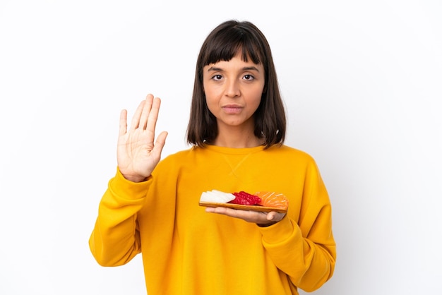 Jonge gemengd ras vrouw met sashimi geïsoleerd op een witte achtergrond stop gebaar maken