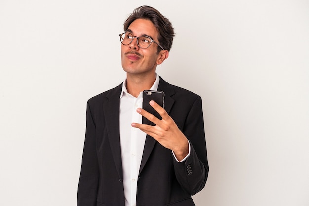 Jonge gemengd ras zakenman met mobiele telefoon geïsoleerd op een witte achtergrond dromen van het bereiken van doelen en doeleinden