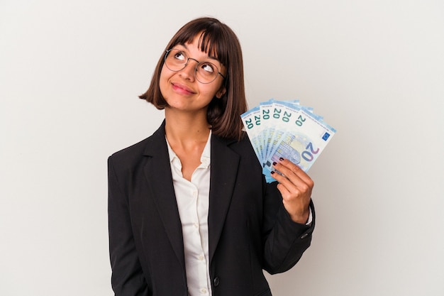 Jonge gemengd ras zakenvrouw met een bankbiljetten geïsoleerd op een witte achtergrond dromen van het bereiken van doelen en doeleinden