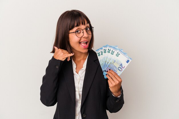 Jonge gemengd ras zakenvrouw met een bankbiljetten geïsoleerd op een witte achtergrond met een mobiel telefoongesprek gebaar met vingers.