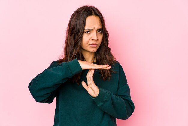 Jonge gemengde geïsoleerde ras Spaanse vrouw die een onderbrekingsgebaar toont.