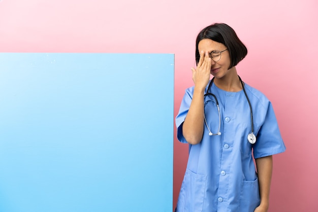 Jonge gemengde raschirurgenvrouw met een grote banner over geïsoleerde muur met hoofdpijn