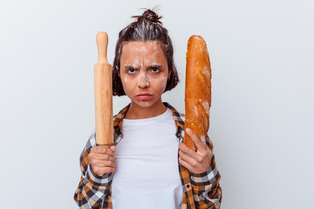 Foto jonge gemengde rasvrouw die brood maakt dat op witte muur wordt geïsoleerd