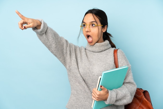 Jonge gemengde rasvrouw die naar school gaan geïsoleerd op blauw weg wijzen